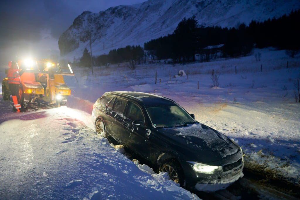 Two truck towing a vehicle from the ditch in snowy conditions near Hot Springs, SD.