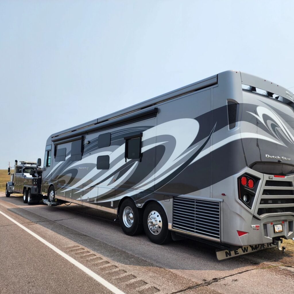 heavy duty towing wrecker pulling large rv bus rear view