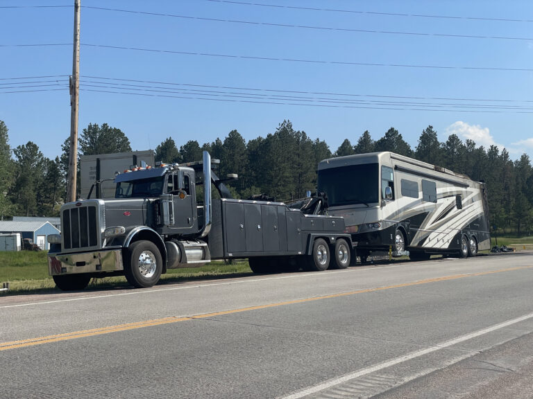 lj's recovery and transport heavy duty towing wrecker towing large rv bus on side of road